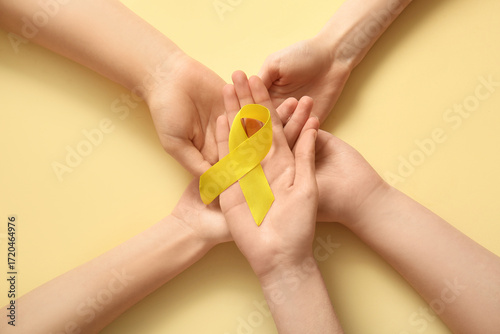 Billede på lærred Yellow awareness ribbon in cupped hands support and solidarity for childhood can