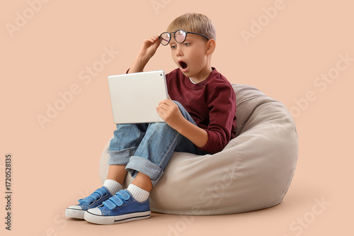 Shocked little boy with tab...