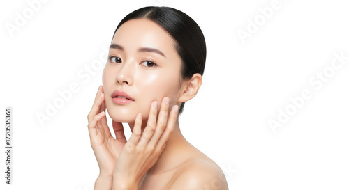 A beautiful asian woman with glowing skin gently touches her face with both hands, looking forward isolated on transparent background