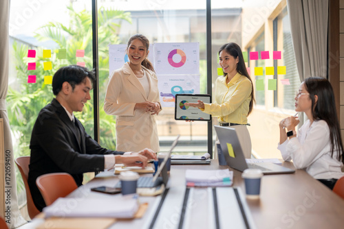Free Download Businesswomen showing pie chart on tablet during office meeting - GFXLoad