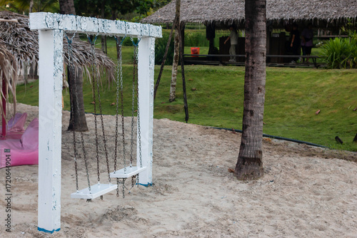 white swing on the artificial sea behind are beautiful green mountains