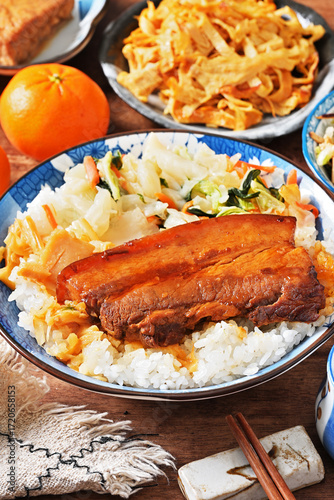 Braised pork belly rice is a beloved Taiwanese dish featuring a thick slice of soy-braised pork belly served over steamed white rice.