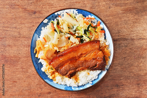Braised pork belly rice is a beloved Taiwanese dish featuring a thick slice of soy-braised pork belly served over steamed white rice.