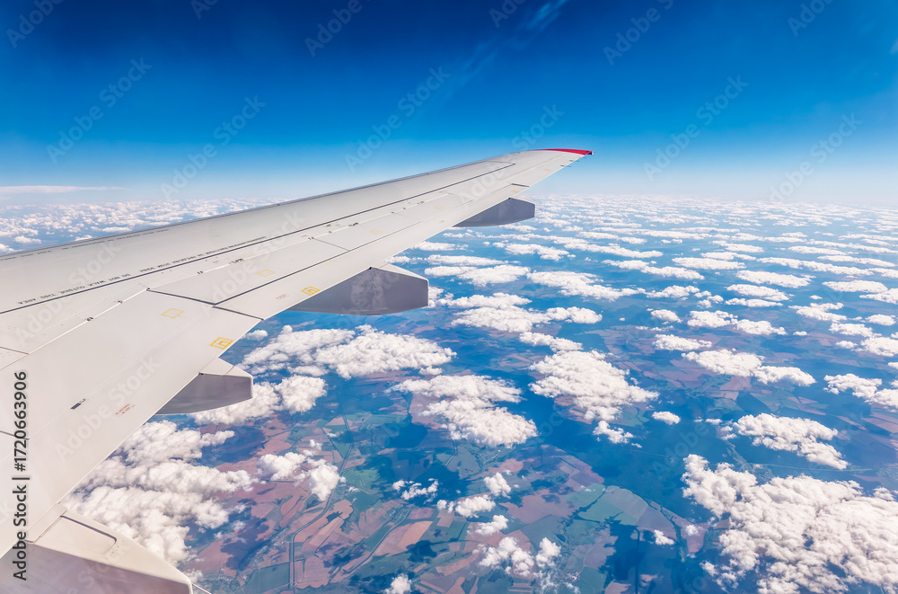Obraz premium View from the airplane window at a beautiful cloudy sky and the airplane wing
