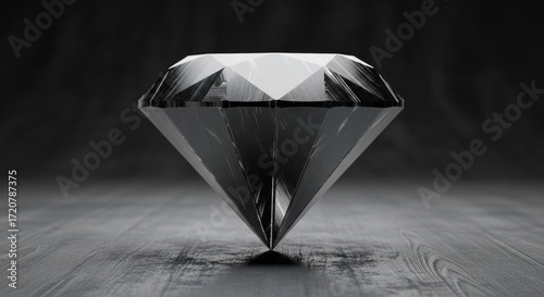 A black diamond shine on a gray solid surface dark background