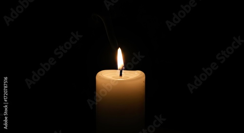 close up of white candle lit in dark room