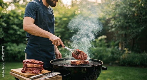 man cooking steak on grill in backyard