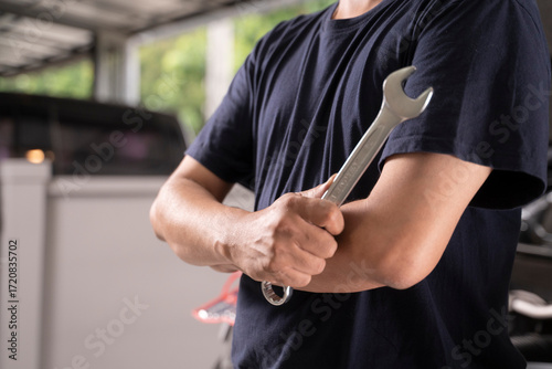 A man with a wrench is ready to do some basic car maintenance.