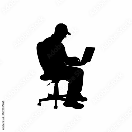 Silhouette of a technician working on a laptop in a server room