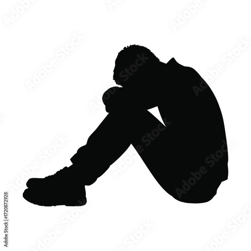 Silhouette of a person sitting with head down in despair