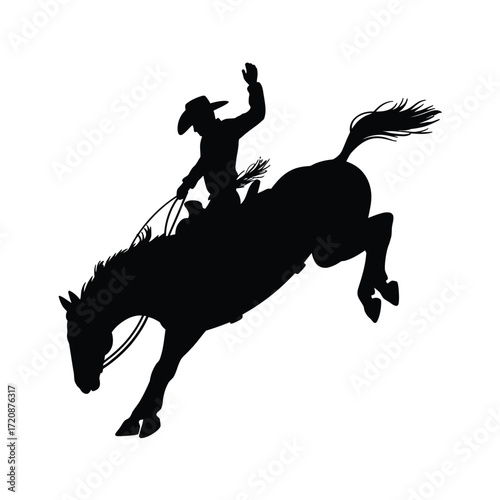Silhouette of a cowboy riding a bucking bronco
