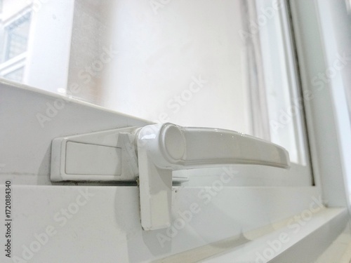 White window handle. White aluminum window lock.