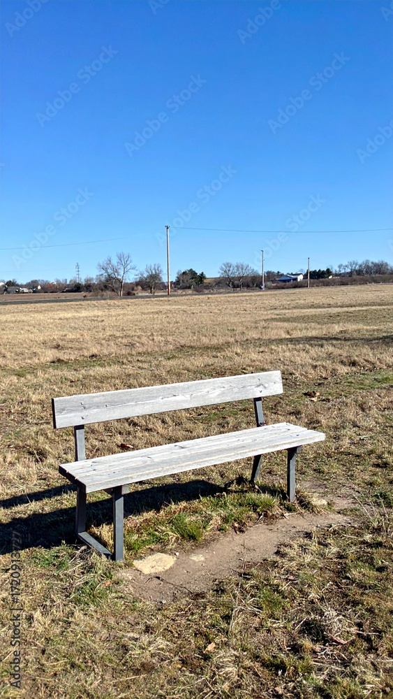 Obraz premium Wooden bench in open field