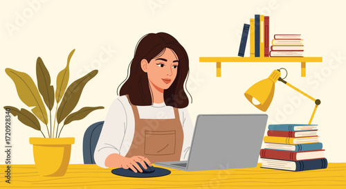 A woman is working on her laptop at a desk with books and a plant.