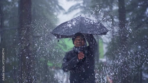 A man holding an umbrella during a snowstorm in Patnitop, Jammu and Kashmir, India.