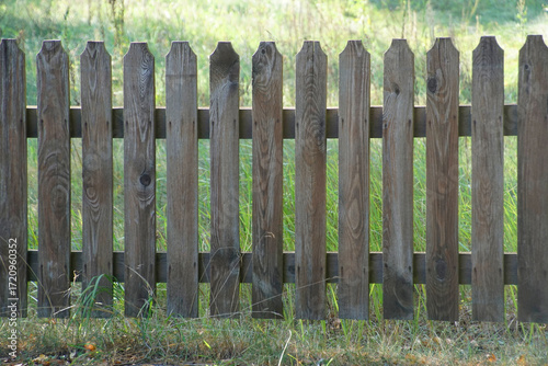 A fence made of planks. Enclosing a space. An outdoor installation.