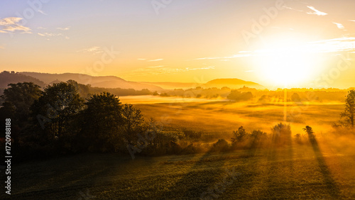 Radiant Morning Sunlight Over Rural Landscape With Misty Fields