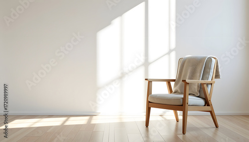 Minimalist empty room with a wooden armchair and sunlight shadows.