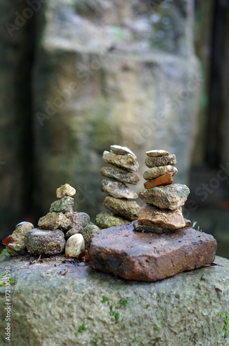 Stacked rocks in a forest with moss and natural textures.