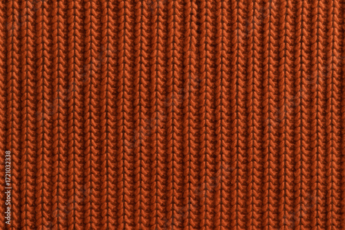 Close-up of orange knitted wool fabric with vertical ribbed pattern. Warm textured background for fashion, handmade crafts, cozy winter clothing and interior design