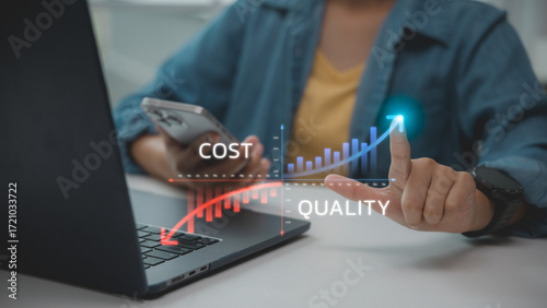 Bilde på lerret Business hand pointing at virtual graph showing decreasing cost and increasing quality