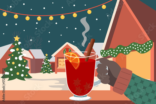 Hand with glass of gluhwein or mulled wine to toast the holiday at a German Christmas night market or christkindlmärkte. Hot beverage with alcohol, star anise and citrus fruit at a local outdoor fair