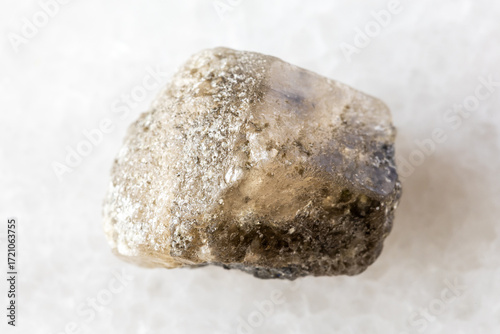 sample of rough phenakite mineral on white marble