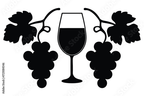 Silhouette wine glass stands between black grapes and leaves in pure elegance