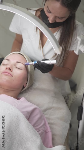 A woman is receiving a professional facial treatment at a beauty clinic. 