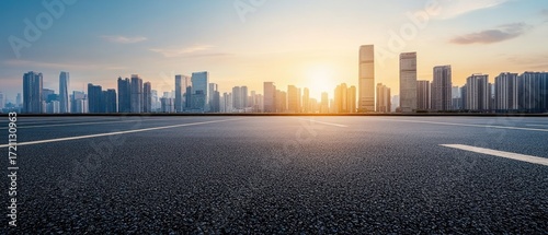 Asphalt road leads to city skyline at sunset (1)