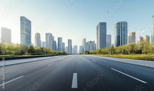 Empty city road leading to modern skyscrapers under a clear sky