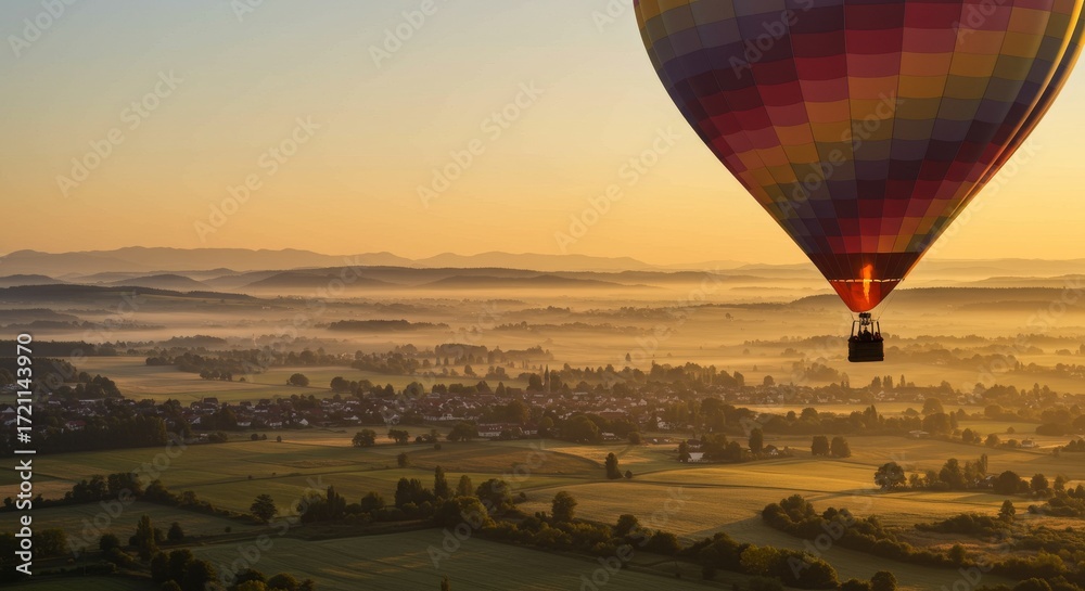 Fototapeta premium Colorful Hot Air Balloon Over Scenic Landscape at Sunrise