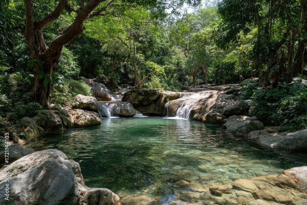 Naklejka premium Tranquil waterfall pool nestled in lush green forest