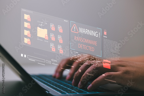 Ransomware detection alert with locked file folders and warning interface on screen, hands typing on laptop during cyberattack, showing data encryption, file access denial, and digital extortion risk.