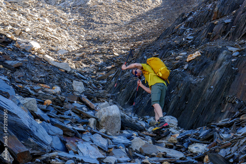 Escursionista sale tra gli sfasciumi verso il Pizzo Scopì - Piz Miez, Passo del Lucomagno, Svizzera