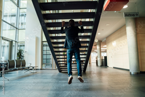 Confident business senior keeps fit with back training during office break
