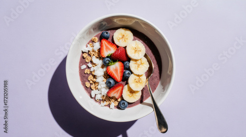 Acai bowl with fruit and granola on a pastel lavender background, clean top-down studio shot