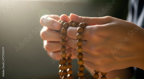 Hands Holding Wooden Prayer Beads for Meditation and Reflection