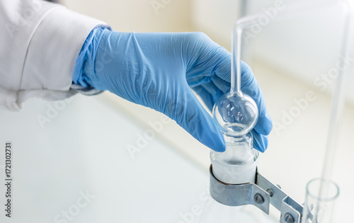 A female chemist assembles a device for distilling and absorbing arsenic in food products.