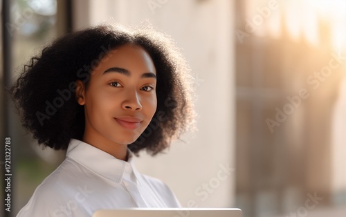 Young professional woman using laptop outside in a contemporary business district environment.