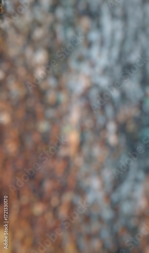 This is a highly blurred, out-of-focus abstract image of a textured surface, likely a tree trunk. 