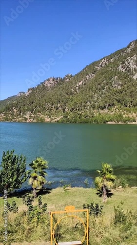A beautiful lake with green and blue water in a picturesque mountain forest location, on a sunny summer day.