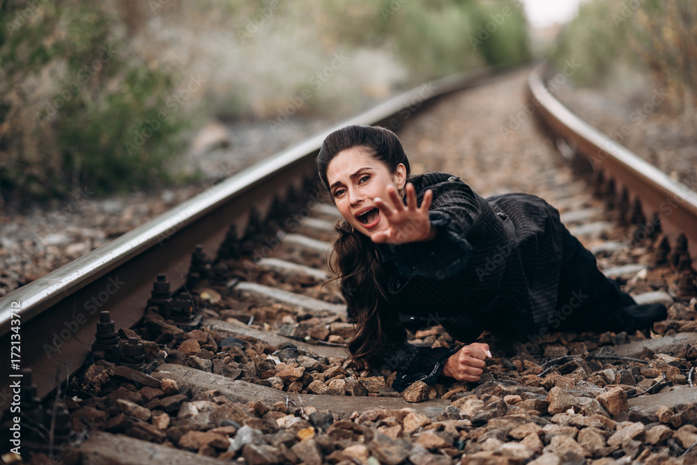 Fototapeta premium Woman in Emotional Expression on Railway Tracks Photo