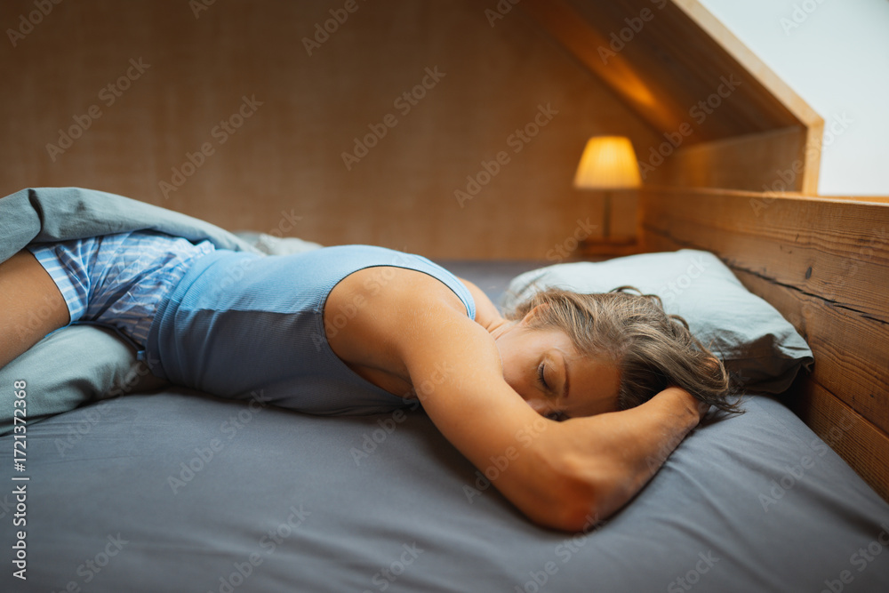 Obraz premium A beautifully peaceful scene featuring a person resting quietly and comfortably in a cozy, minimalist bedroom