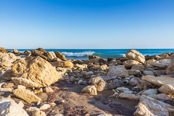 Papier peint photo   Evening Cyprus Seashore with Rocks on Sandy Beach and Sunset Horizon  © Alla