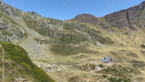 Hikers enjoy the landscape in the Pyrenees mountain range during a break in the walk