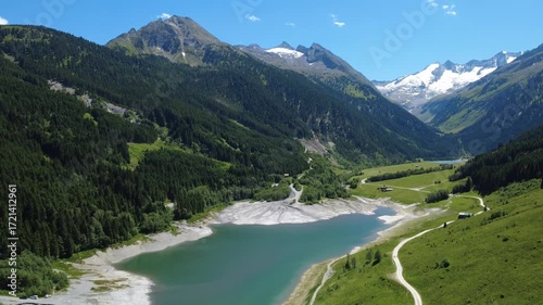 Stunning Aerial View of an Alpine Valley with a Serene Lake in the Austrian Alps