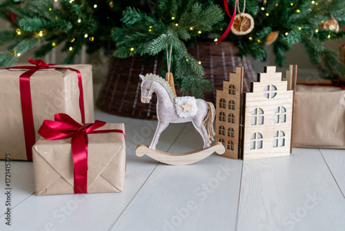 Christmas decorations: gifts, a toy horse, a folding house under the christmas tree