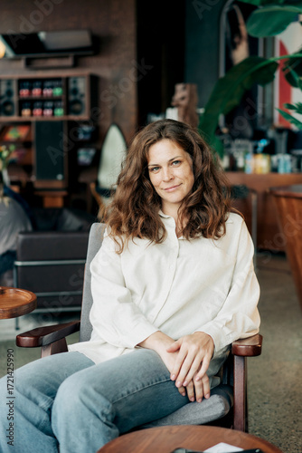Portrait of a beautiful red-haired woman of thirty-five years old sitting in a coffee house.