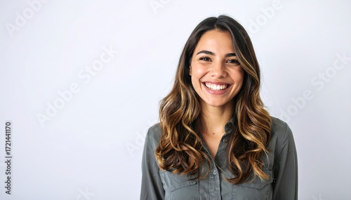 Smiling woman with long, wavy hair against a plain background